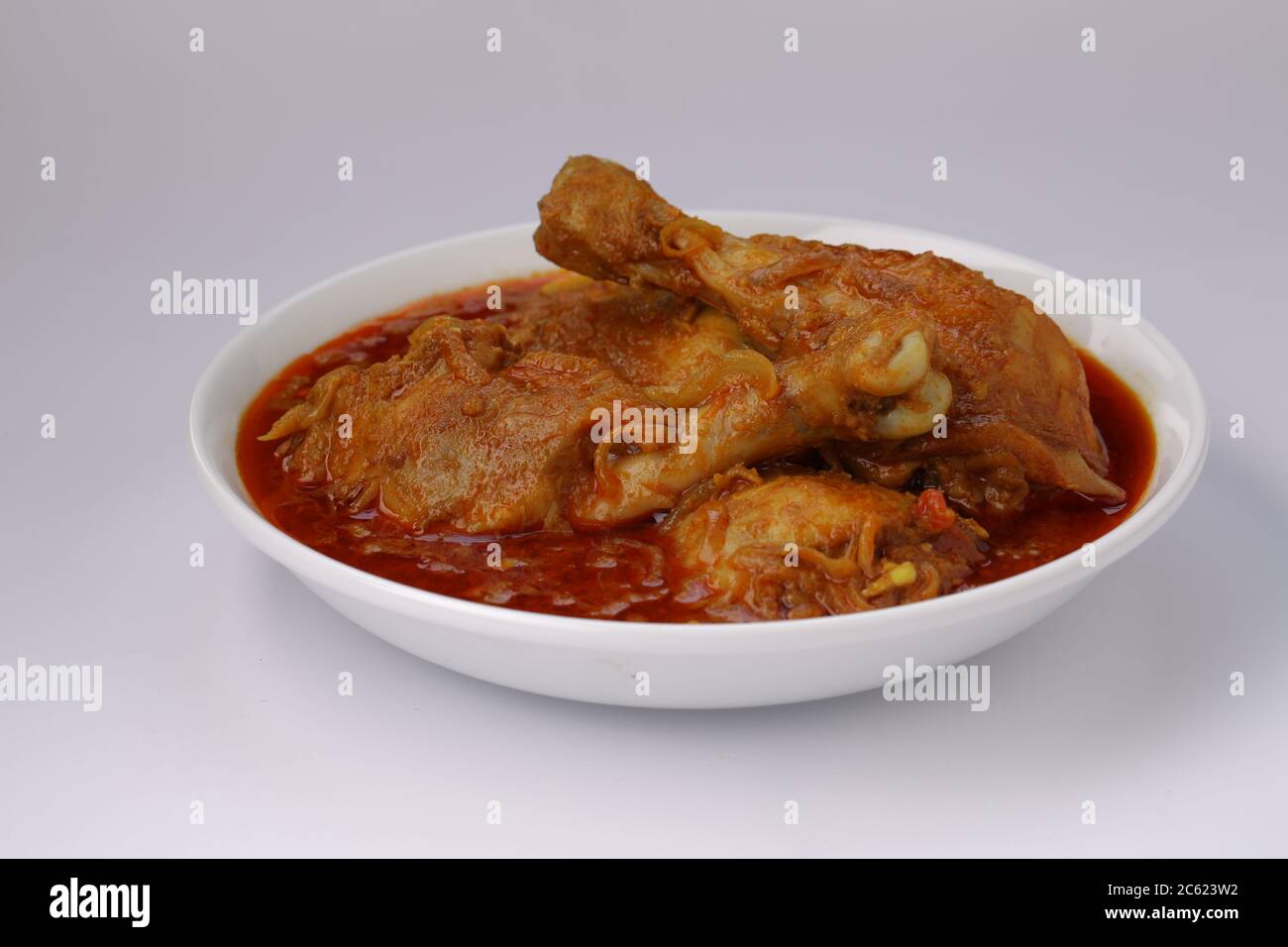 Curry de poulet ou masala, cari épicé de poulet masala fait à l'aide d'épices, oignon et ail dans le style indien du nord dans un bol en céramique blanche Banque D'Images