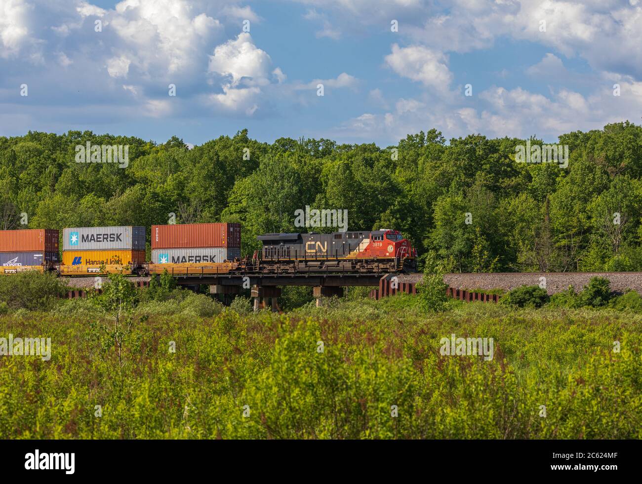Train de marchandises du CN traversant une communauté rurale dans le nord du Wisconsin. Banque D'Images