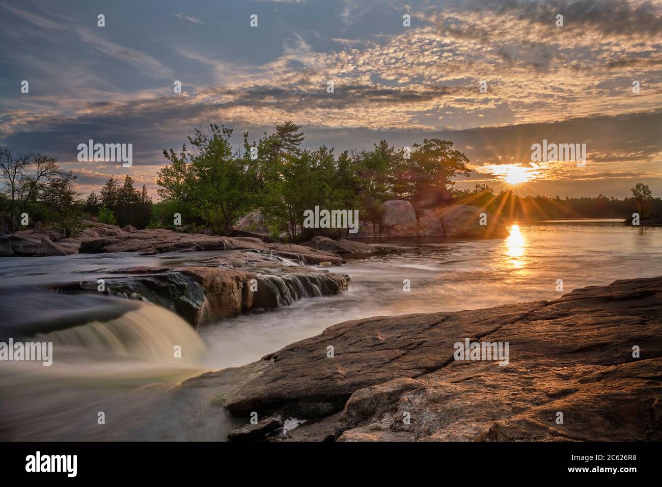 Un magnifique lever de soleil à Burleigh Falls, Ontario, montre un motif de soleil étoilé avec une lumière de lentille colorée Banque D'Images