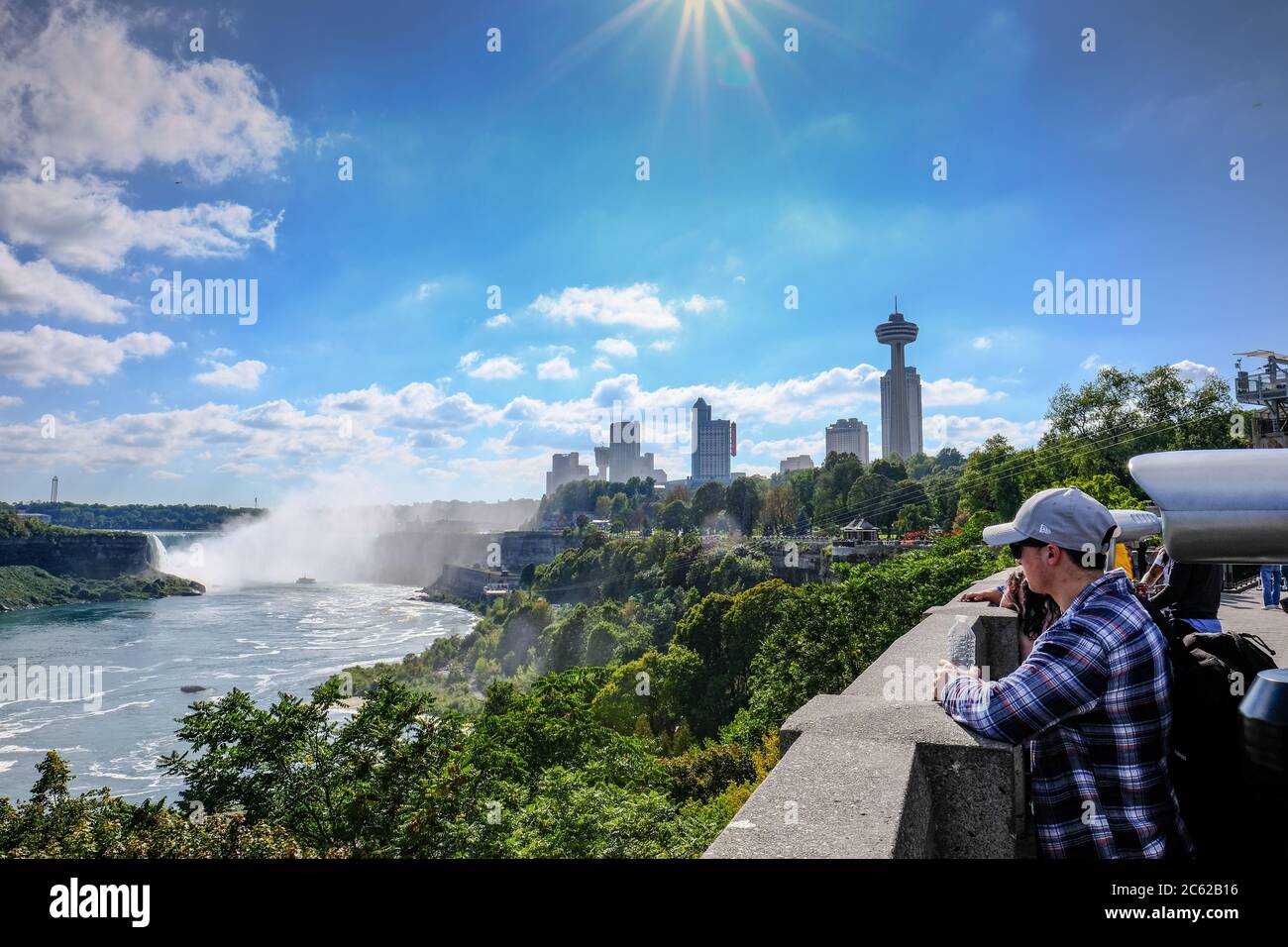 Vue panoramique sur les chutes du Niagara montrant des membres du public qui font la queue pour une excursion en bateau dans une brume intense. Banque D'Images