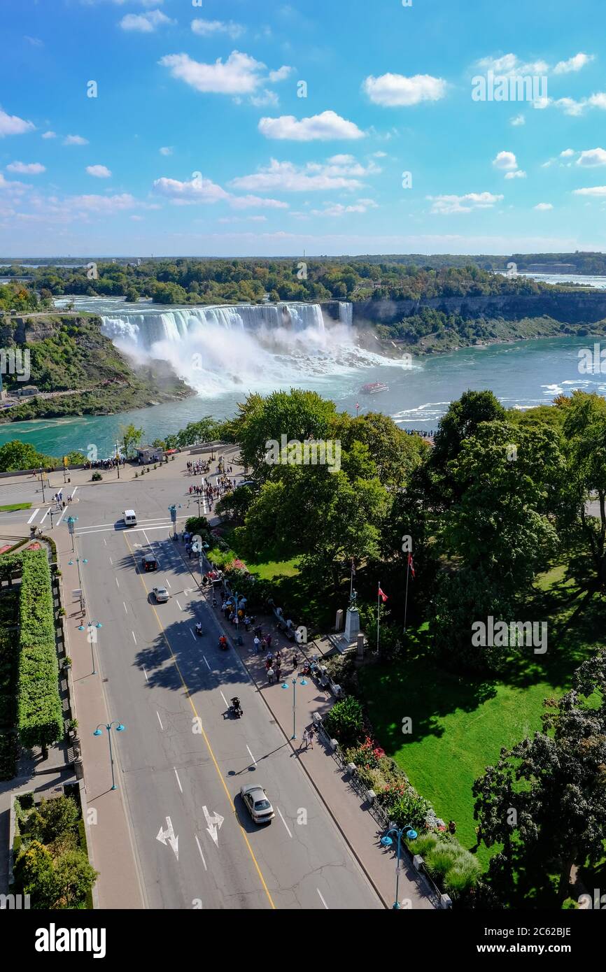 Vue panoramique sur les chutes du Niagara montrant des membres du public qui font la queue pour une excursion en bateau dans une brume intense. Banque D'Images