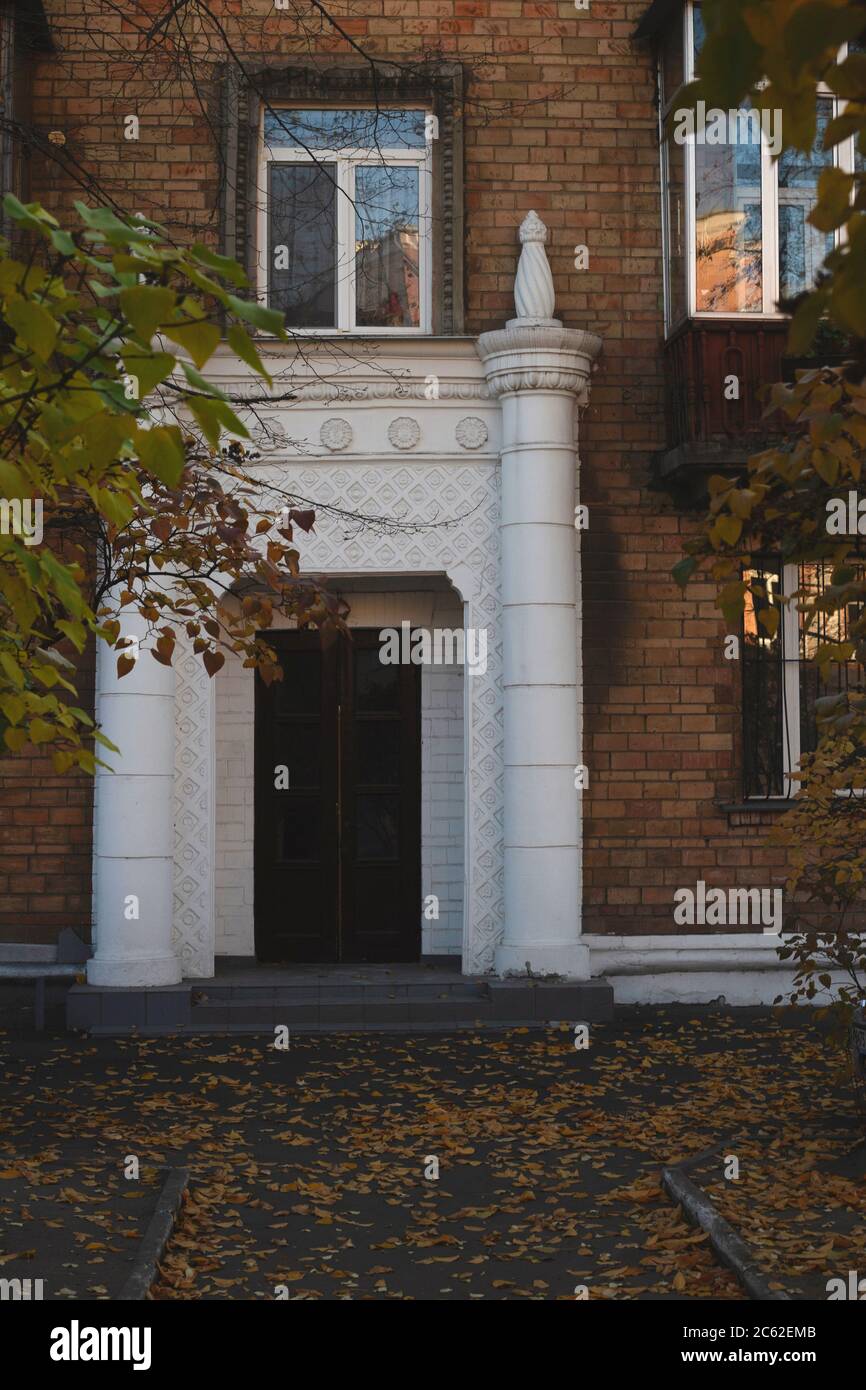 Architecture historique avec colonnes blanches autour de la porte d'entrée d'une maison en brique. Banque D'Images