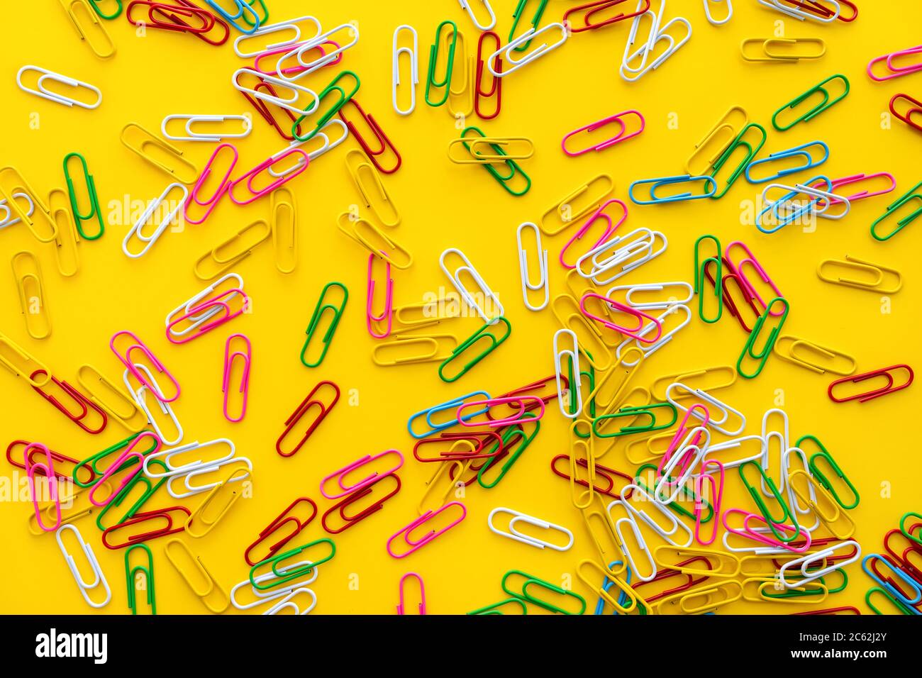 Concept de l'éducation et de la rentrée. Trombones colorés sur fond jaune vif. Banque D'Images