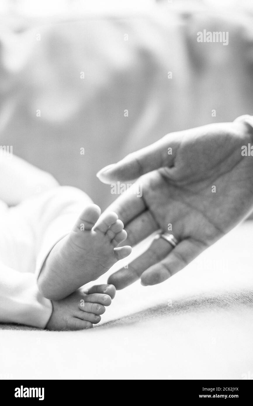 Gros plan de la main de la mère touchant les pieds de bébé Banque D'Images