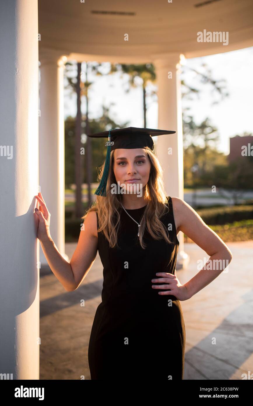 une étudiante pose dans la cour avec un chapeau de remise des diplômes Banque D'Images