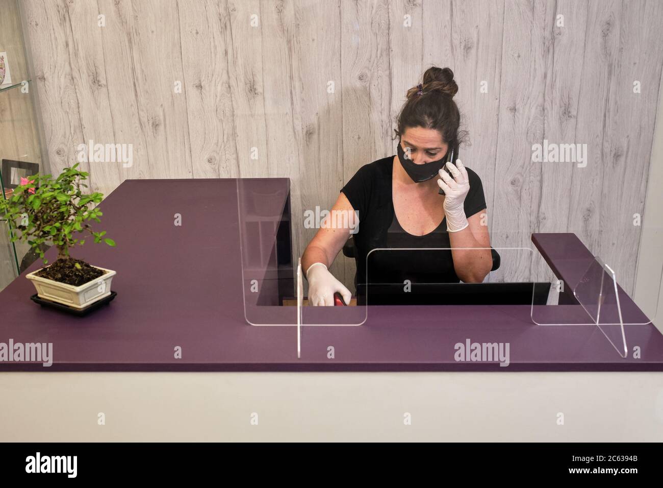 femme gérant la réception de votre entreprise en répondant au téléphone et en prenant rendez-vous Banque D'Images