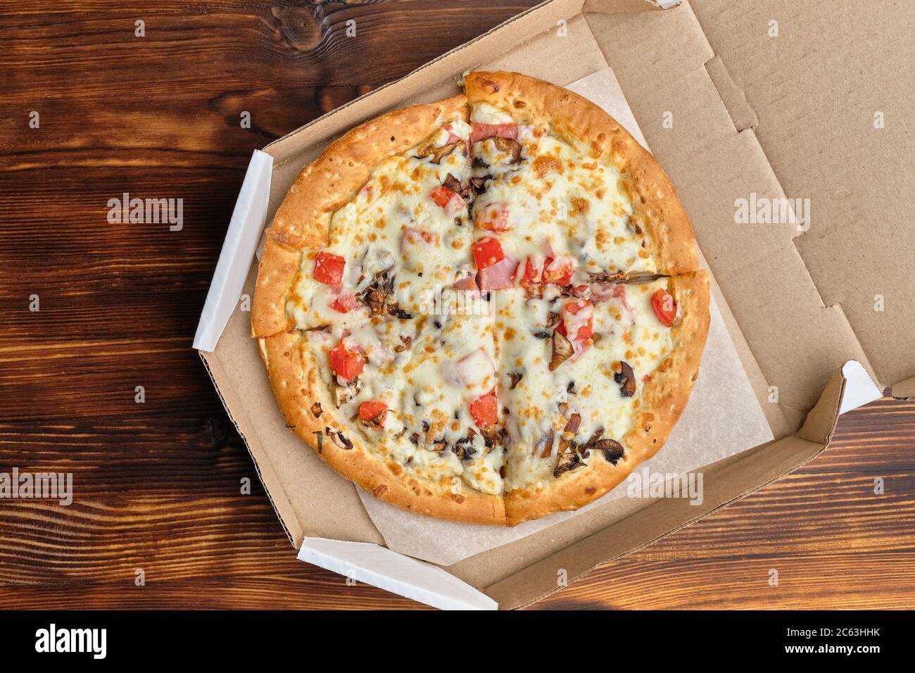 Pizza carbonara dans un emballage en carton sur un fond en bois avec vue de dessus. Banque D'Images