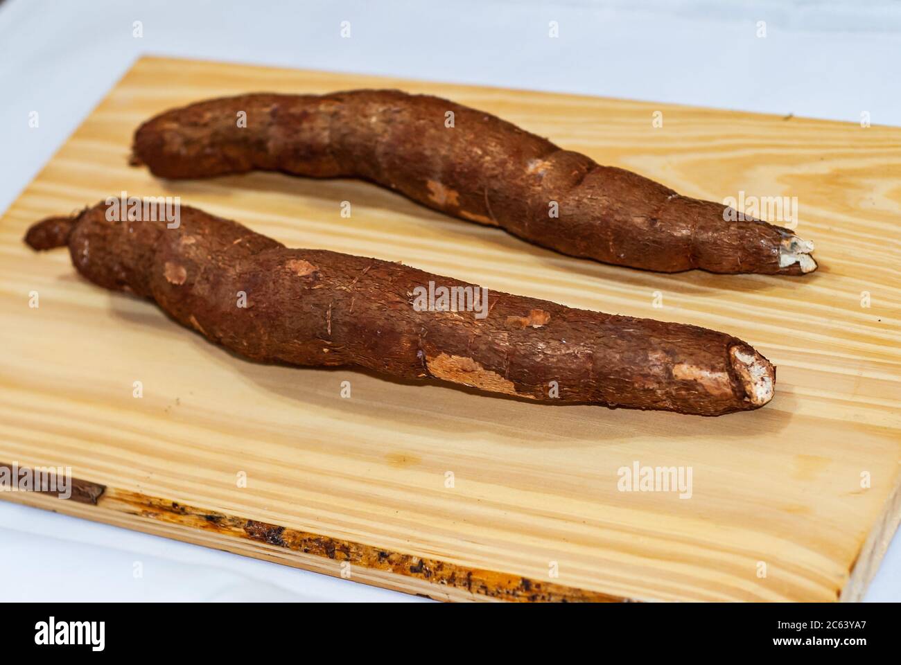 Yucca cru sur la table en bois, Manihot esculenta. (Tubercule brut de manioc). Manioc, également appelé mandica, yuca, balinghoy, mogo, mandica, kamoteng kahoy, Banque D'Images