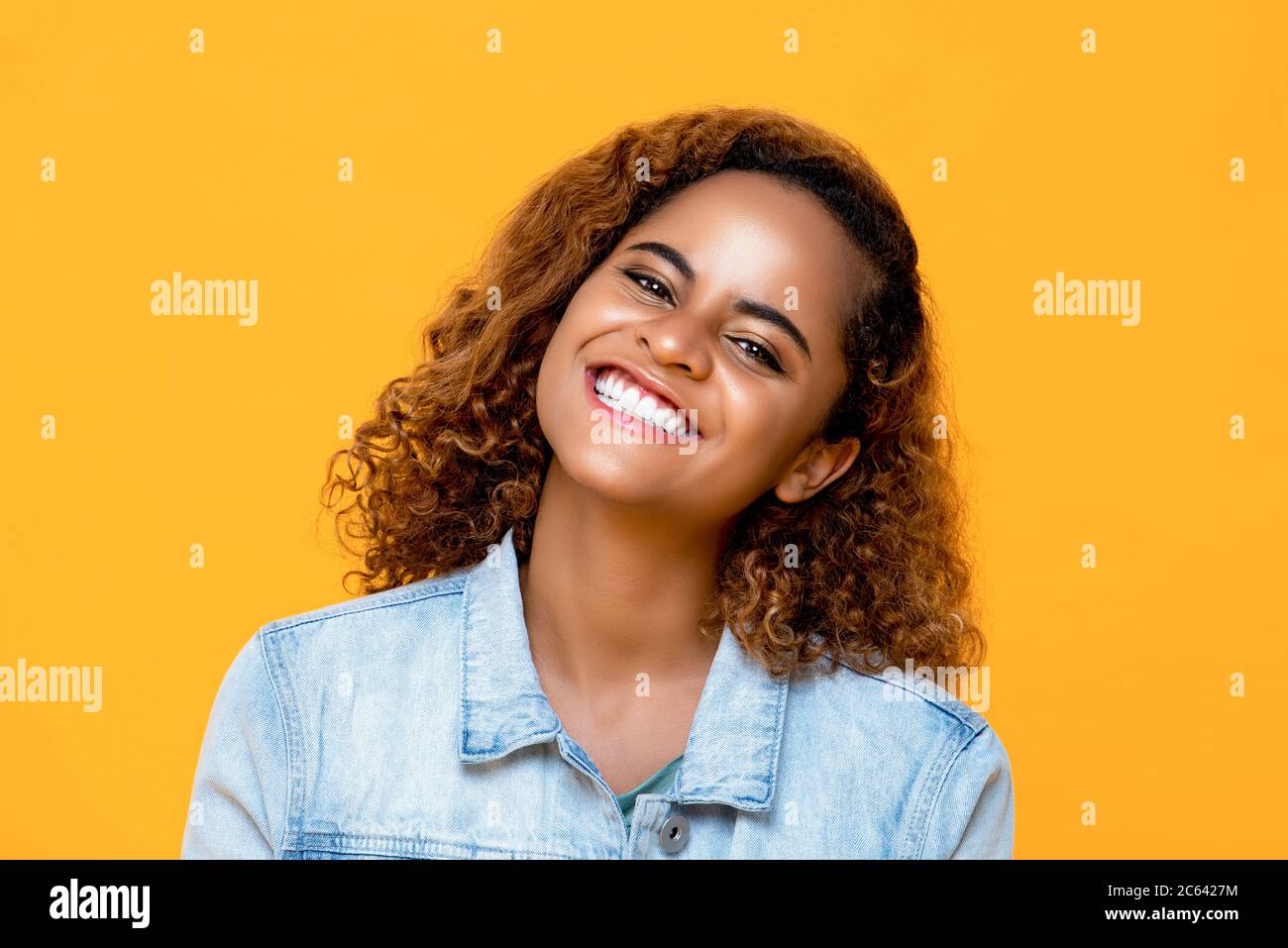 Portrait de la charmante femme afro-américaine souriante isolée sur fond jaune Banque D'Images