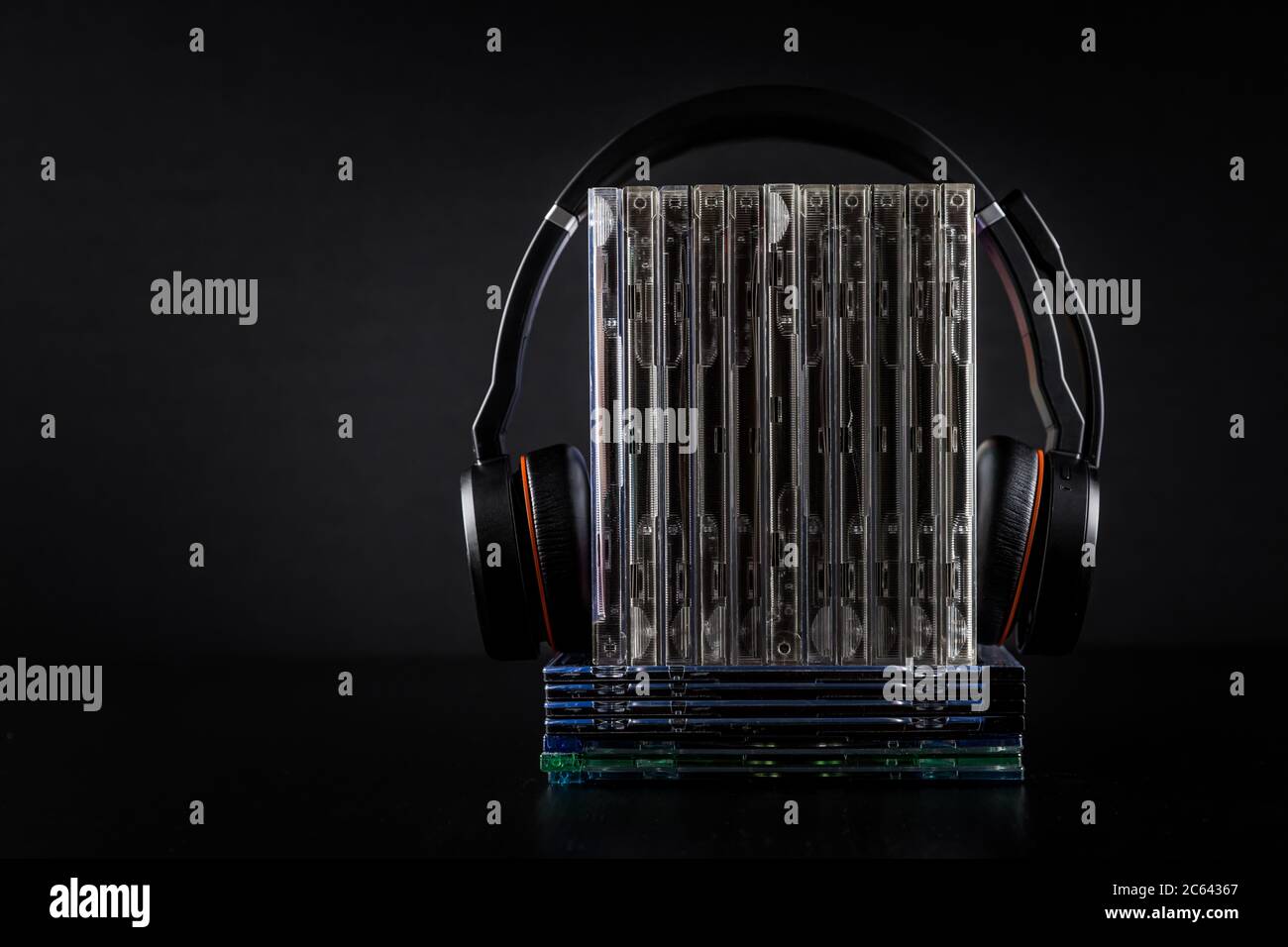 Casque hi-Fi sur pile de CD sur fond noir avec espace de copie. Banque D'Images