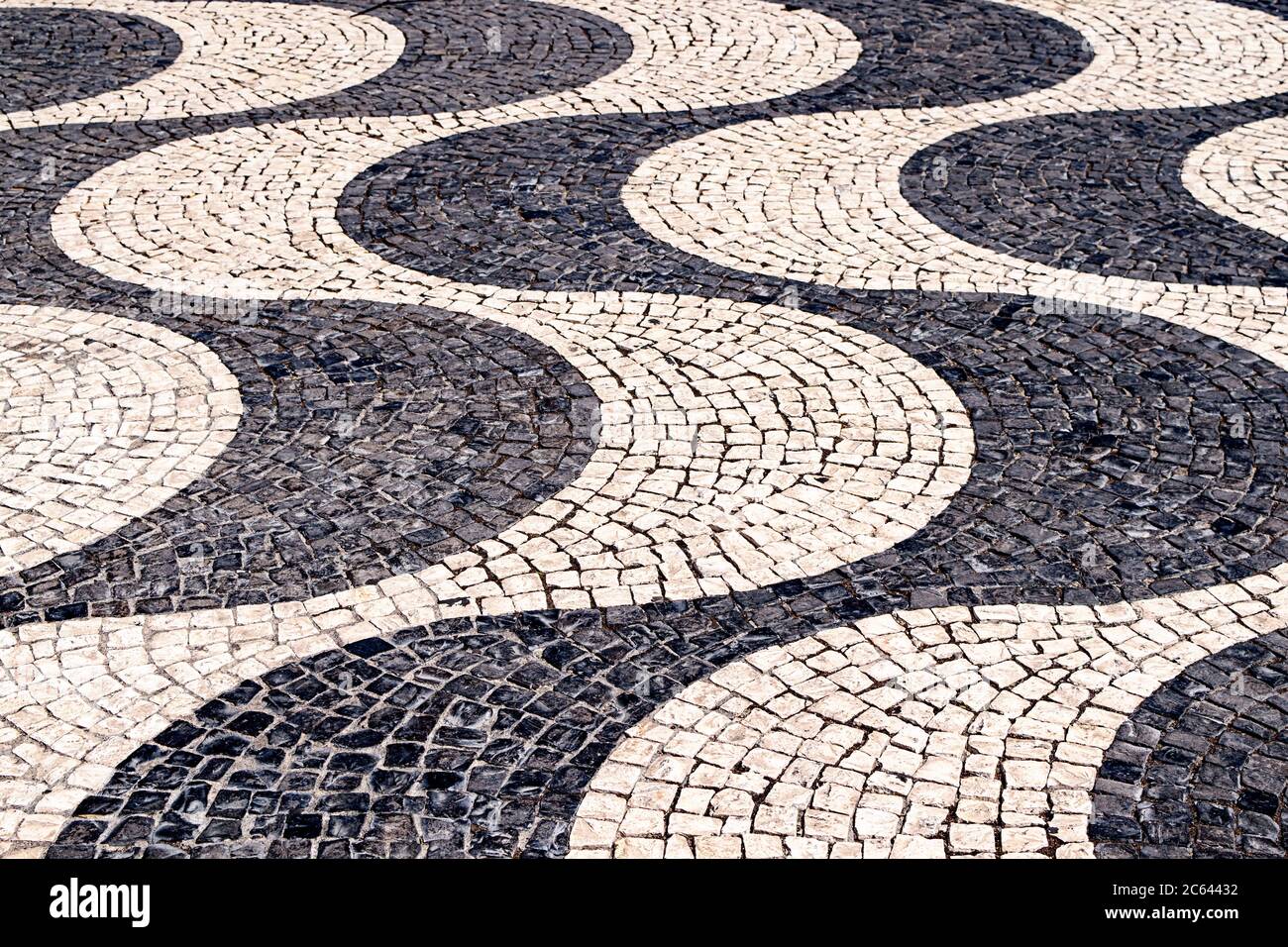 Les pavés portugais noirs et blancs forment des courbes sur la place Rossio, à Lisbonne, au Portugal. Banque D'Images