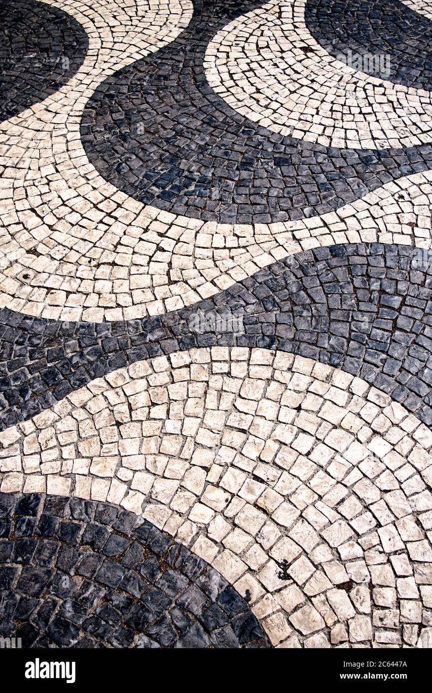Les pavés portugais noirs et blancs appelés calcada forment un modèle de vague à Lisbonne, au Portugal. Banque D'Images