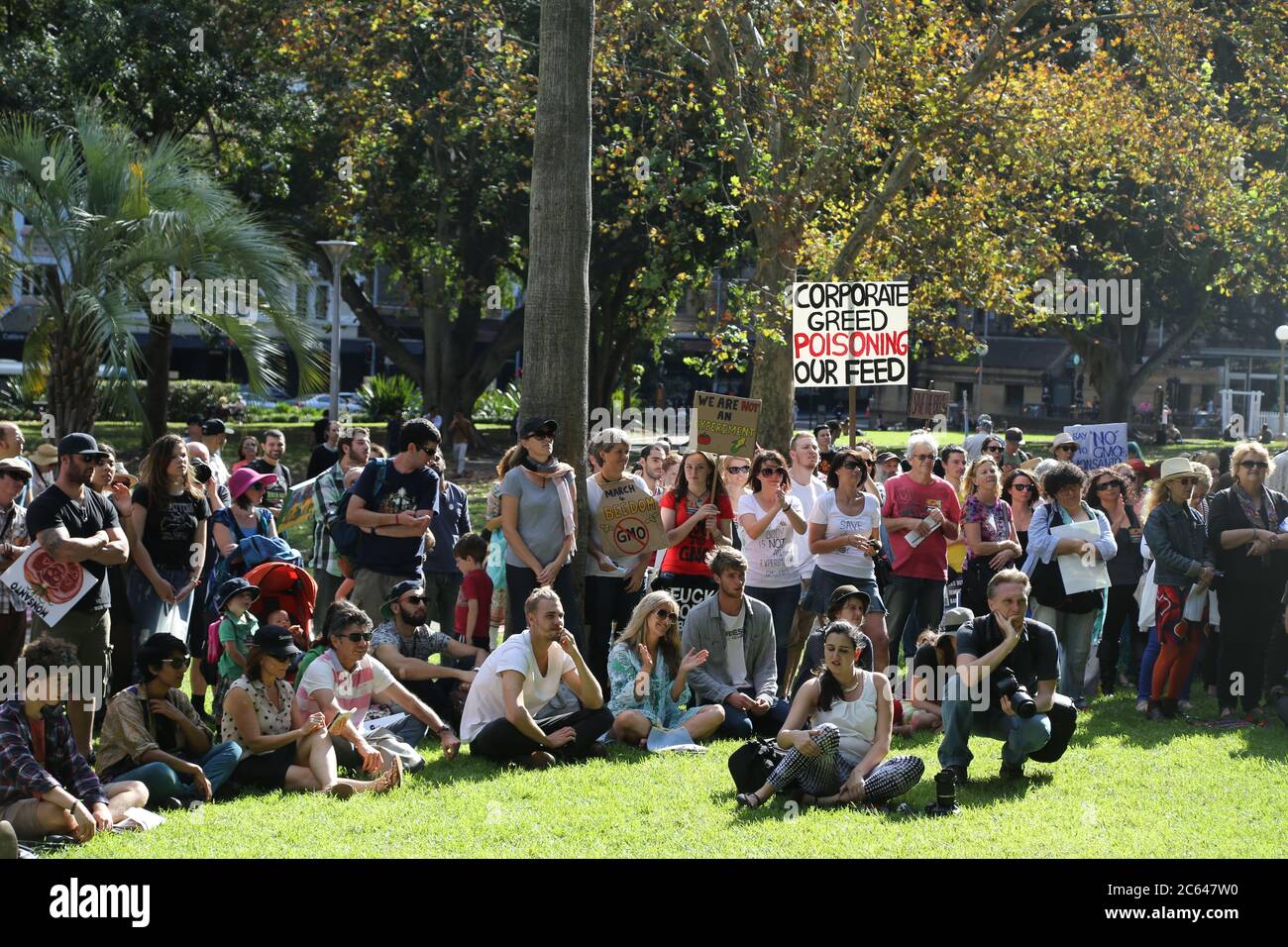 Les manifestants se rassemblent à Hyde Park après une marche de l'hôtel de ville de Sydney lors de la Marche contre Monsanto. Un écriteau dit : « l’avidité des entreprises, empoisonner notre f Banque D'Images