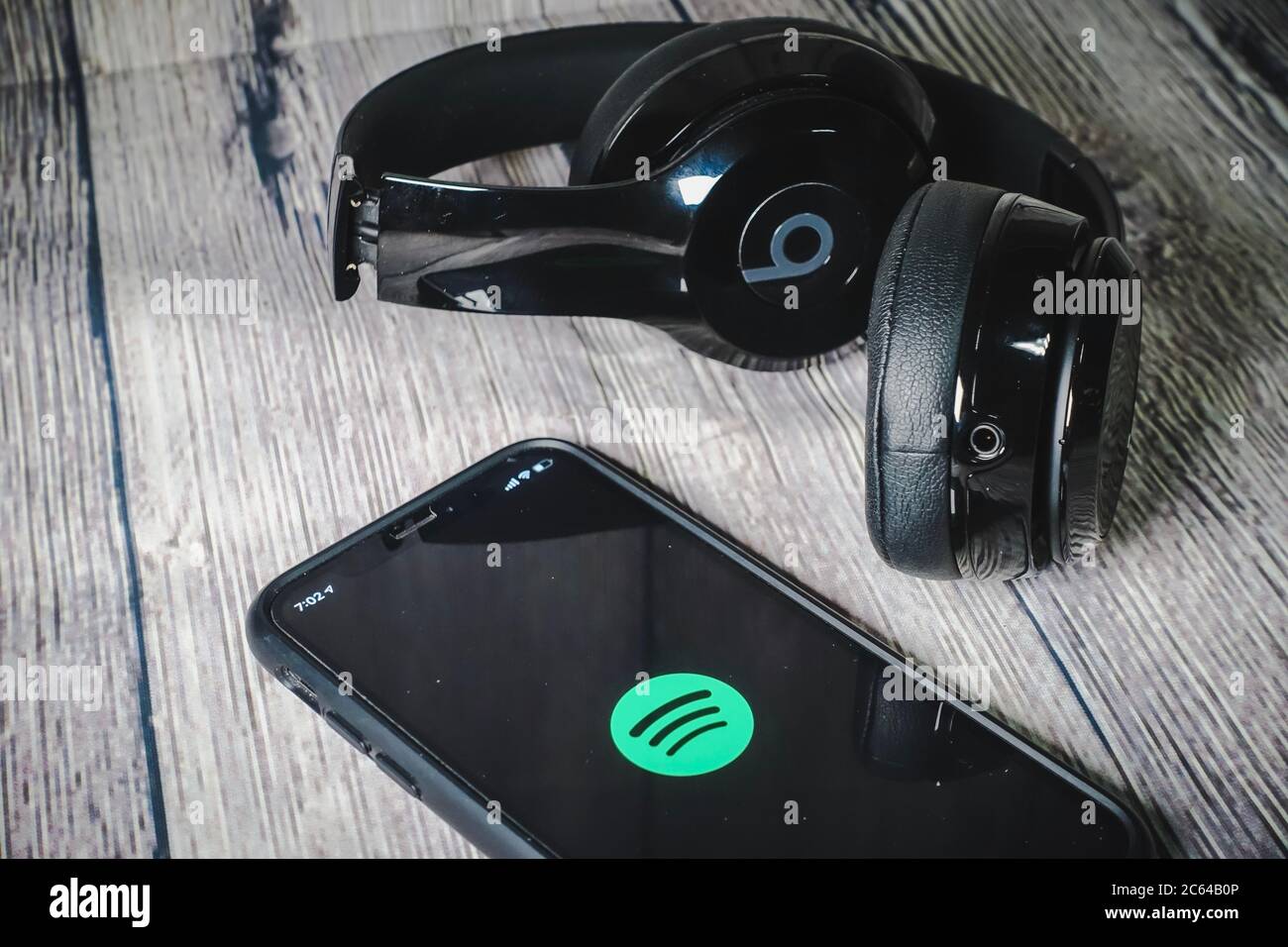 Un écran iphone 11 affichant l'icône spotify avec écouteurs Beats, idéal pour écouter de la musique en déplacement Banque D'Images