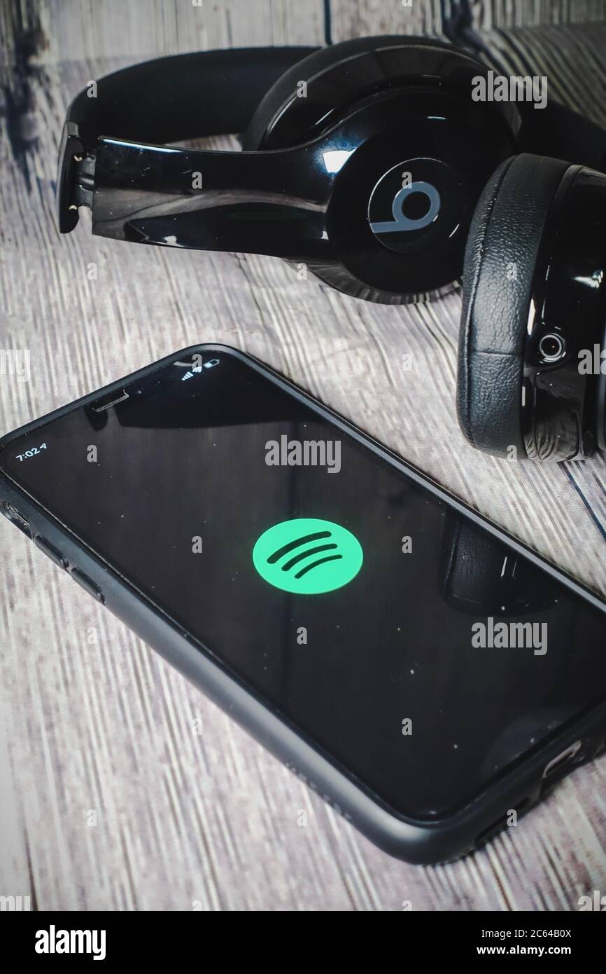 Un écran iphone 11 affichant l'icône spotify avec écouteurs Beats, idéal pour écouter de la musique en déplacement Banque D'Images