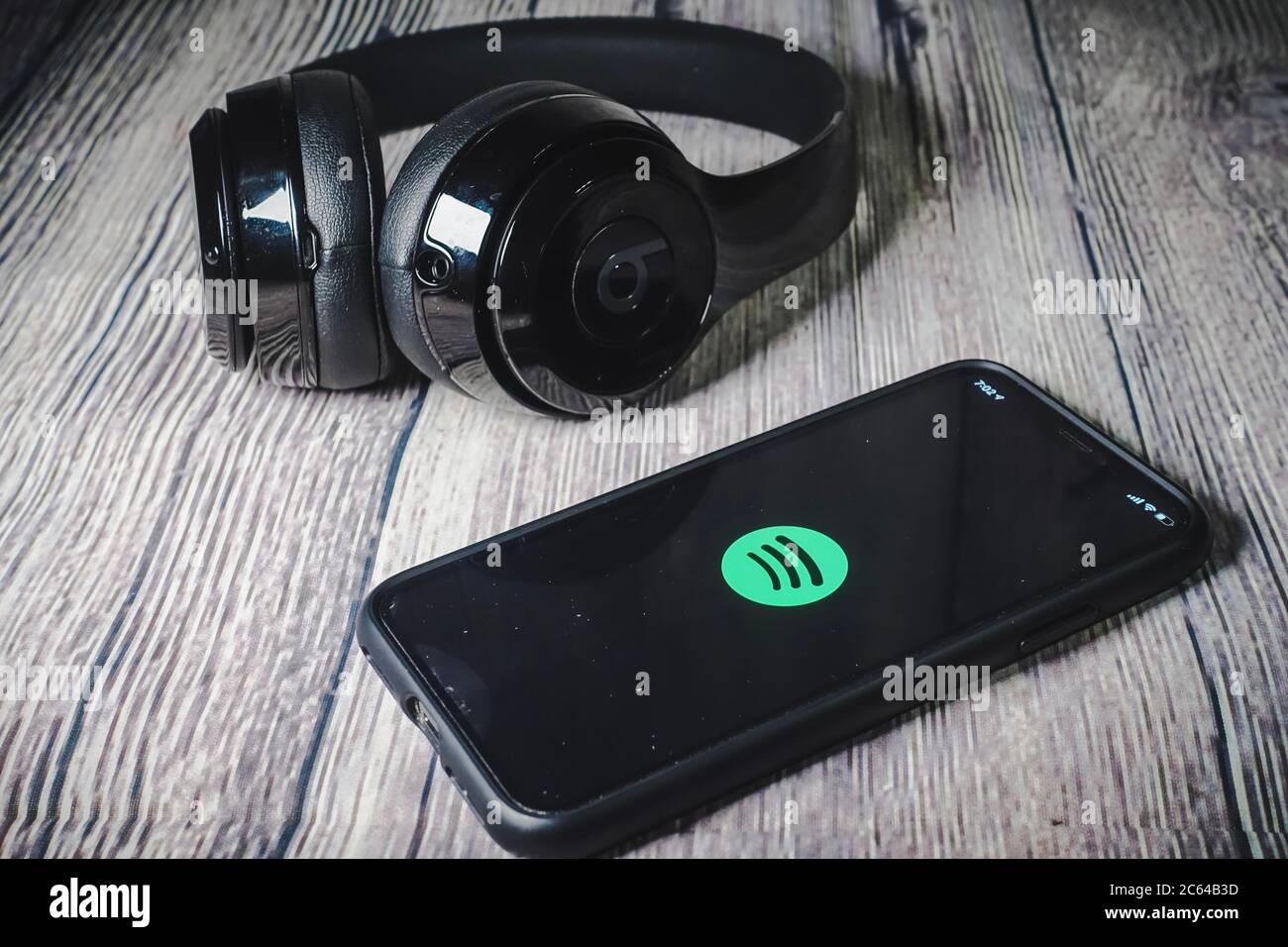 Un écran iphone 11 affichant l'icône spotify avec écouteurs Beats, idéal pour écouter de la musique en déplacement Banque D'Images