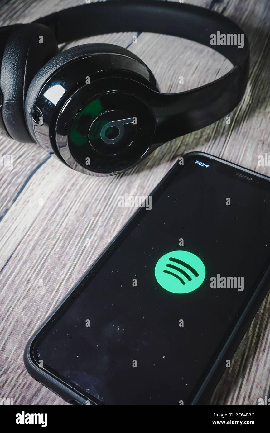 Un écran iphone 11 affichant l'icône spotify avec écouteurs Beats, idéal pour écouter de la musique en déplacement Banque D'Images