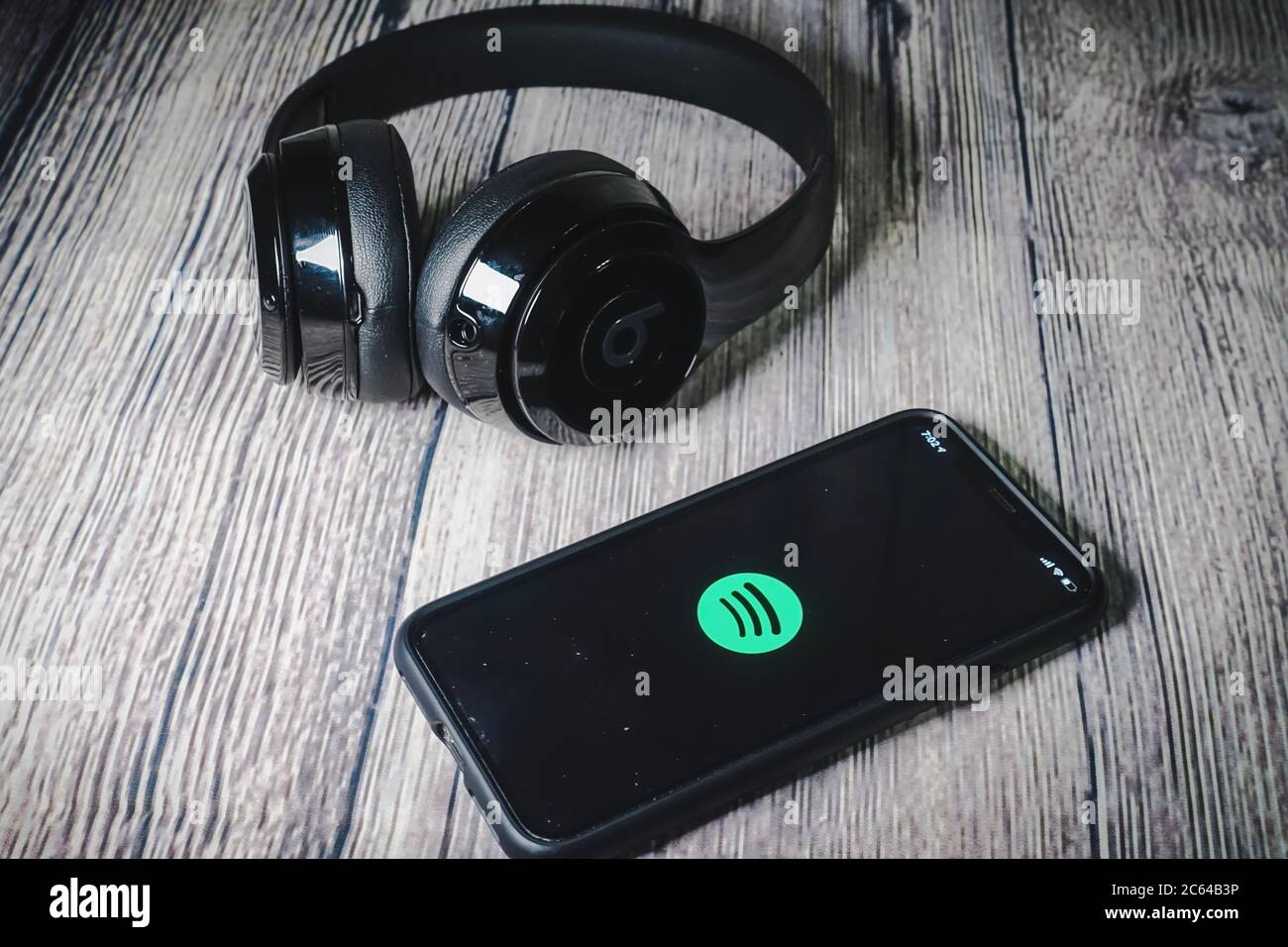 Un écran iphone 11 affichant l'icône spotify avec écouteurs Beats, idéal pour écouter de la musique en déplacement Banque D'Images