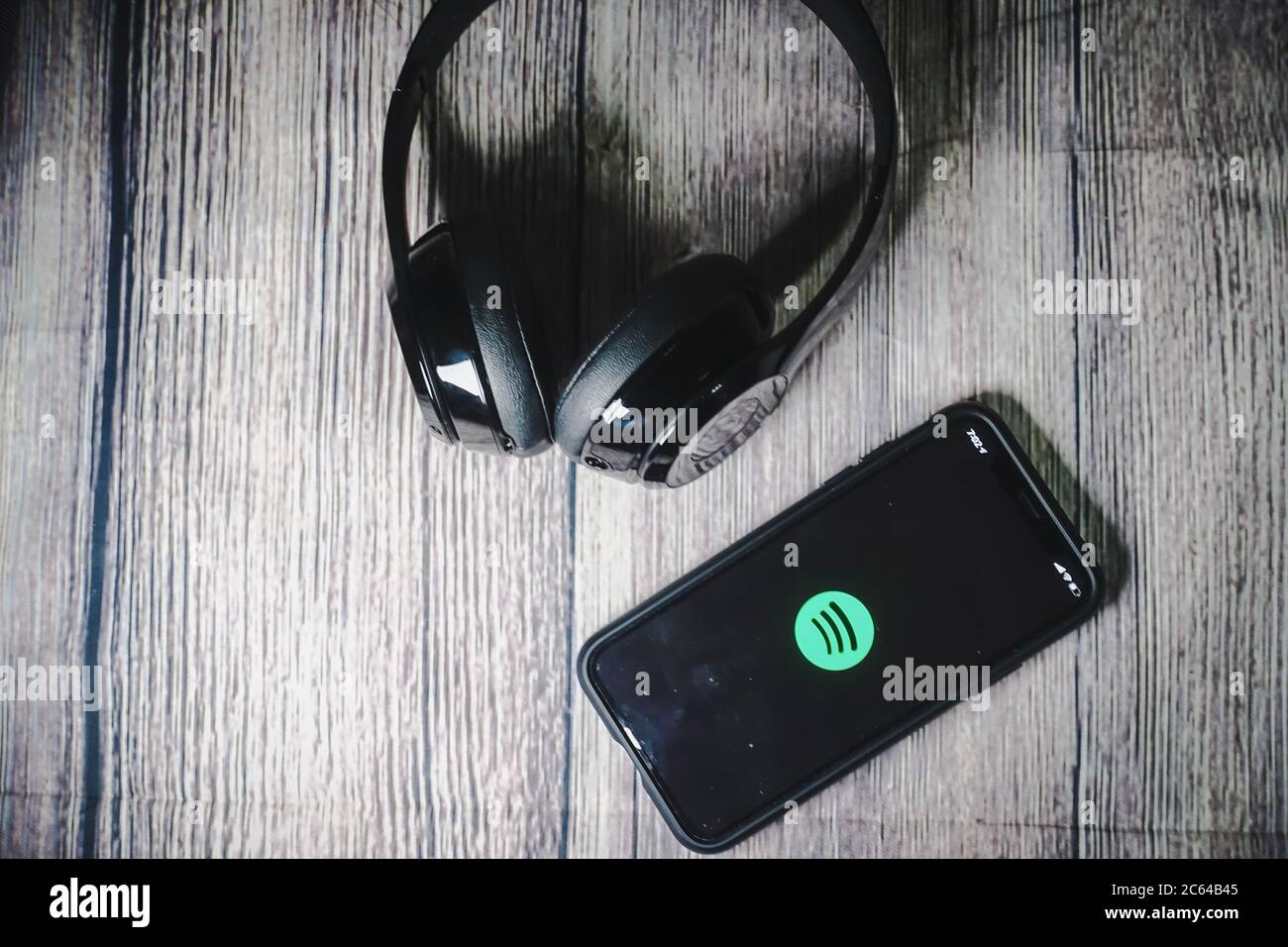 Un écran iphone 11 affichant l'icône spotify avec écouteurs Beats, idéal pour écouter de la musique en déplacement Banque D'Images