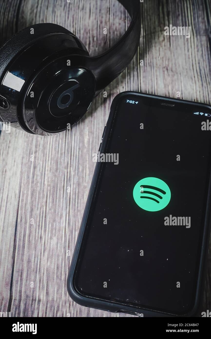 Un écran iphone 11 affichant l'icône spotify avec écouteurs Beats, idéal pour écouter de la musique en déplacement Banque D'Images
