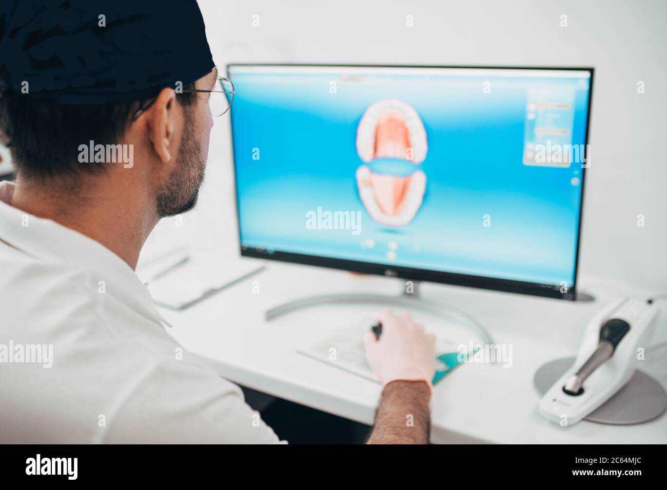 Le dentiste prosthétiste simule une mâchoire humaine sur le moniteur pour la fabrication de prothèses Banque D'Images