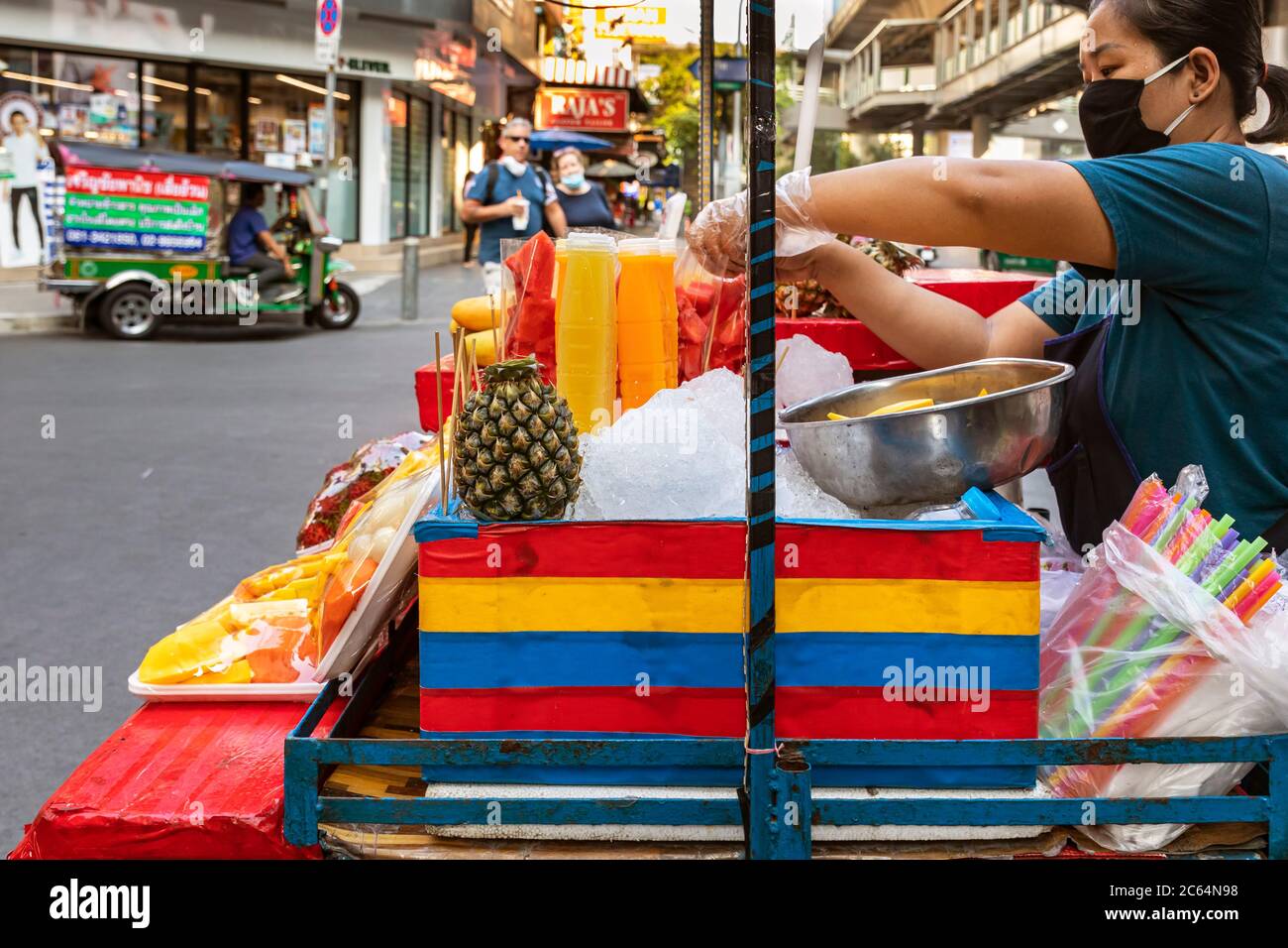 Vendeur de rue avec masque de vente de fruits et jus à emporter pendant la pandémie de Covid 19, Bangkok, Thaïlande Banque D'Images