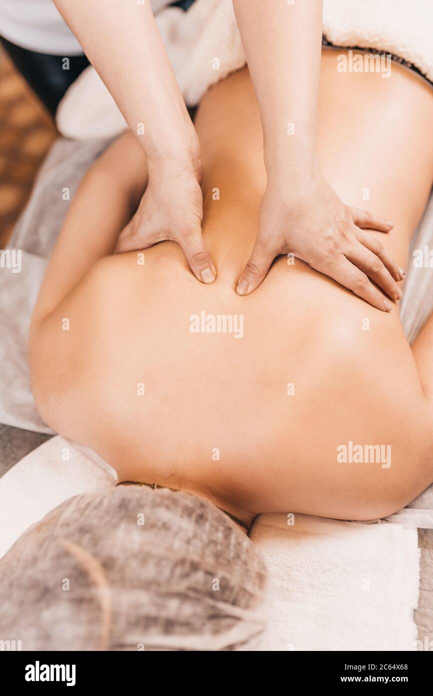 Massage du dos dur à deux mains - impact profond sur les muscles du patient Banque D'Images