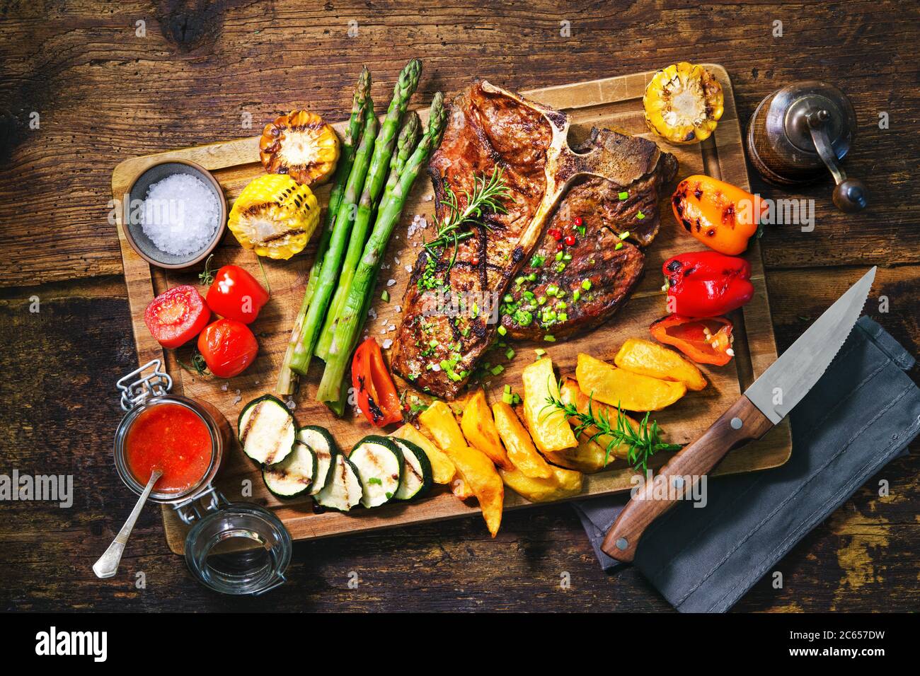 Steak de bœuf avec légumes grillés et assaisonnement sur le plateau de service Banque D'Images