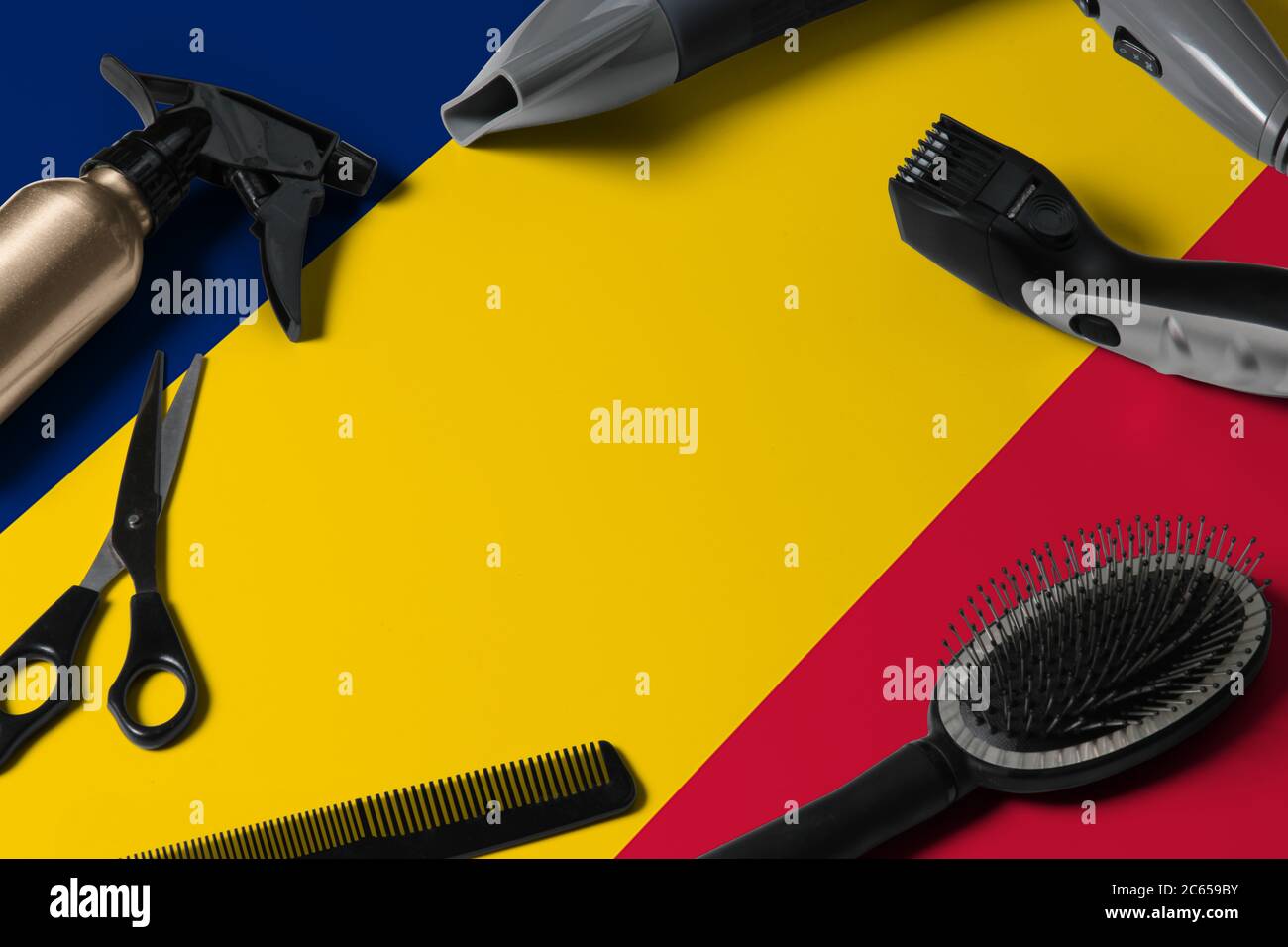 Drapeau du Tchad avec outils de coupe de cheveux. Peignes, ciseaux et outils de coiffure dans un bureau de salon de beauté sur fond national en bois. Banque D'Images