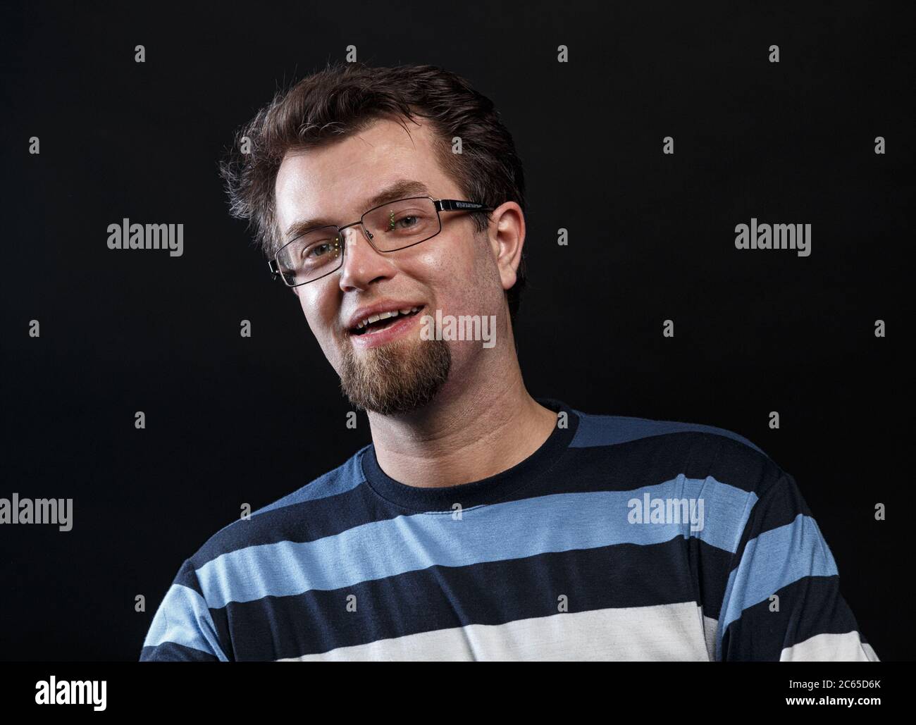 Photo d'un jeune homme barbu souriant en lunettes Banque D'Images