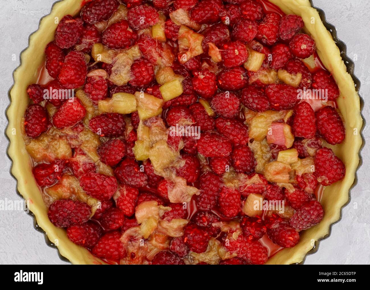 Dans le processus de préparation d'une tarte aux fruits maison avec mûres de mûres et rhubarbe maison et pâtisserie sucrée à croûte courte Banque D'Images