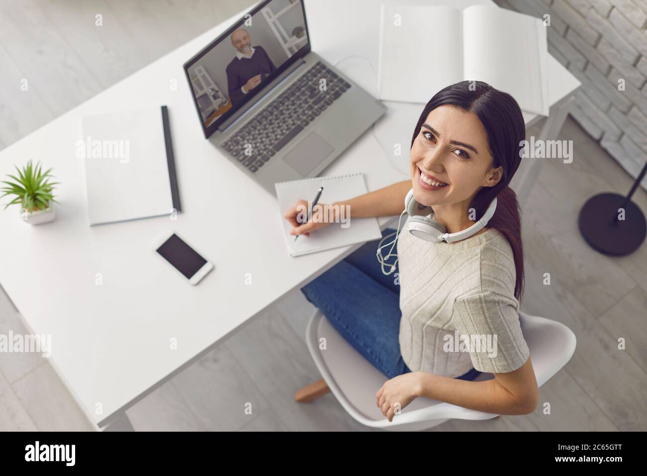 Conférence en ligne. Jeune femme discutant vidéo avec son professeur, son ami, son patron ou sa famille sur un ordinateur portable à la maison, au-dessus de la vue Banque D'Images