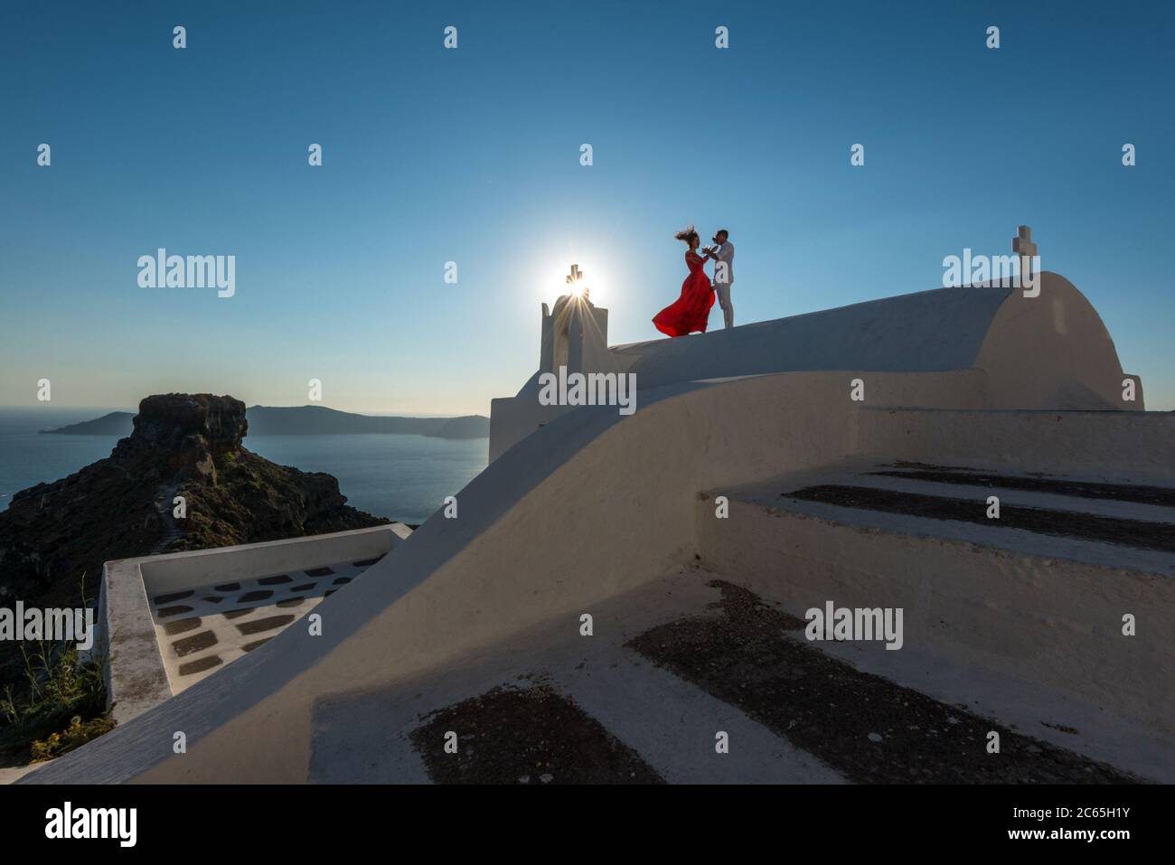 Un toast au coucher du soleil sur le toit du petit chuch d'Agios Georgios surplombant la mer de l'île de Santorini, Imerovigli, Grèce Banque D'Images