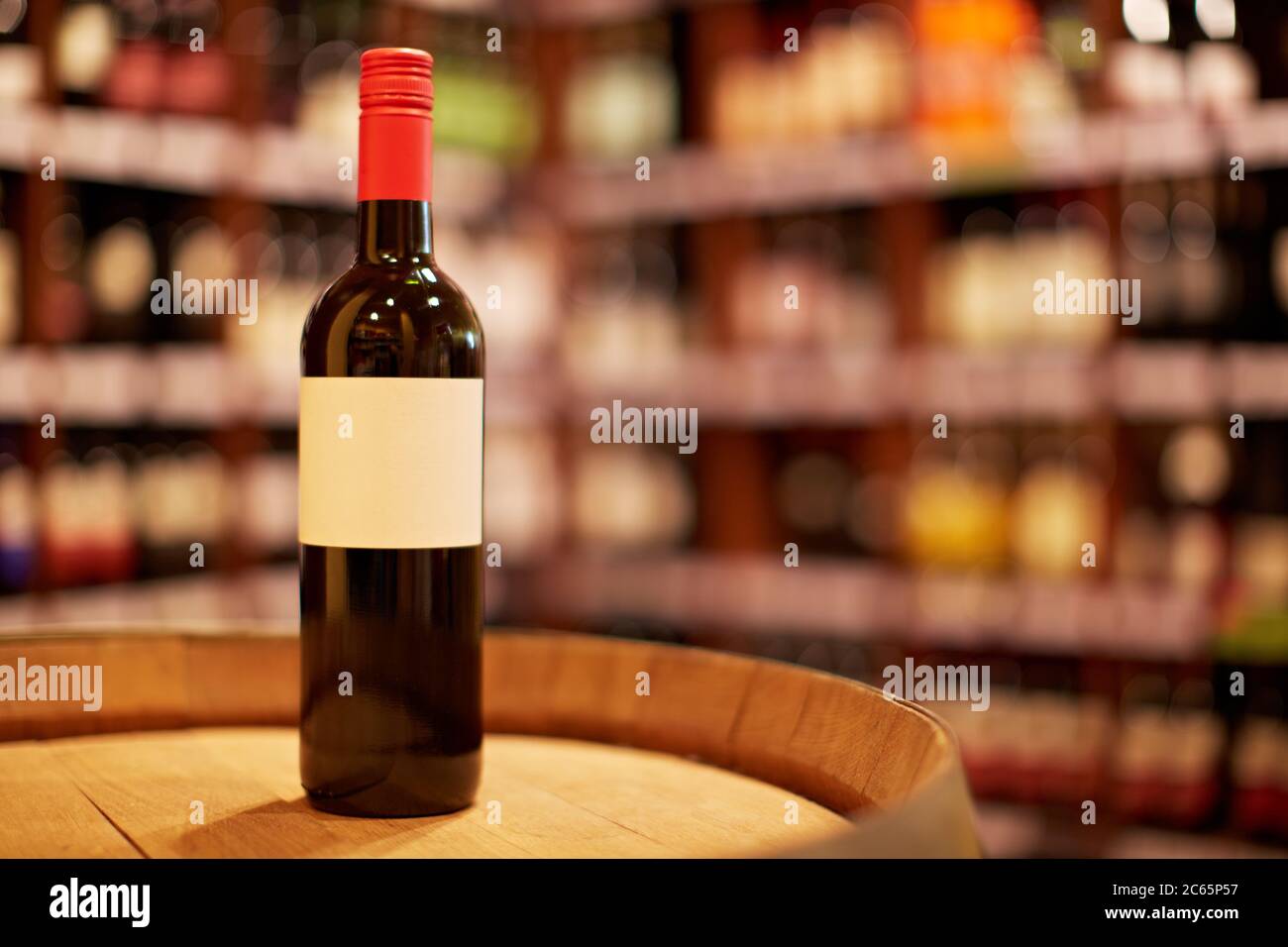 Une bouteille de vin rouge est située sur un fût de vin dans un magasin de vin Banque D'Images