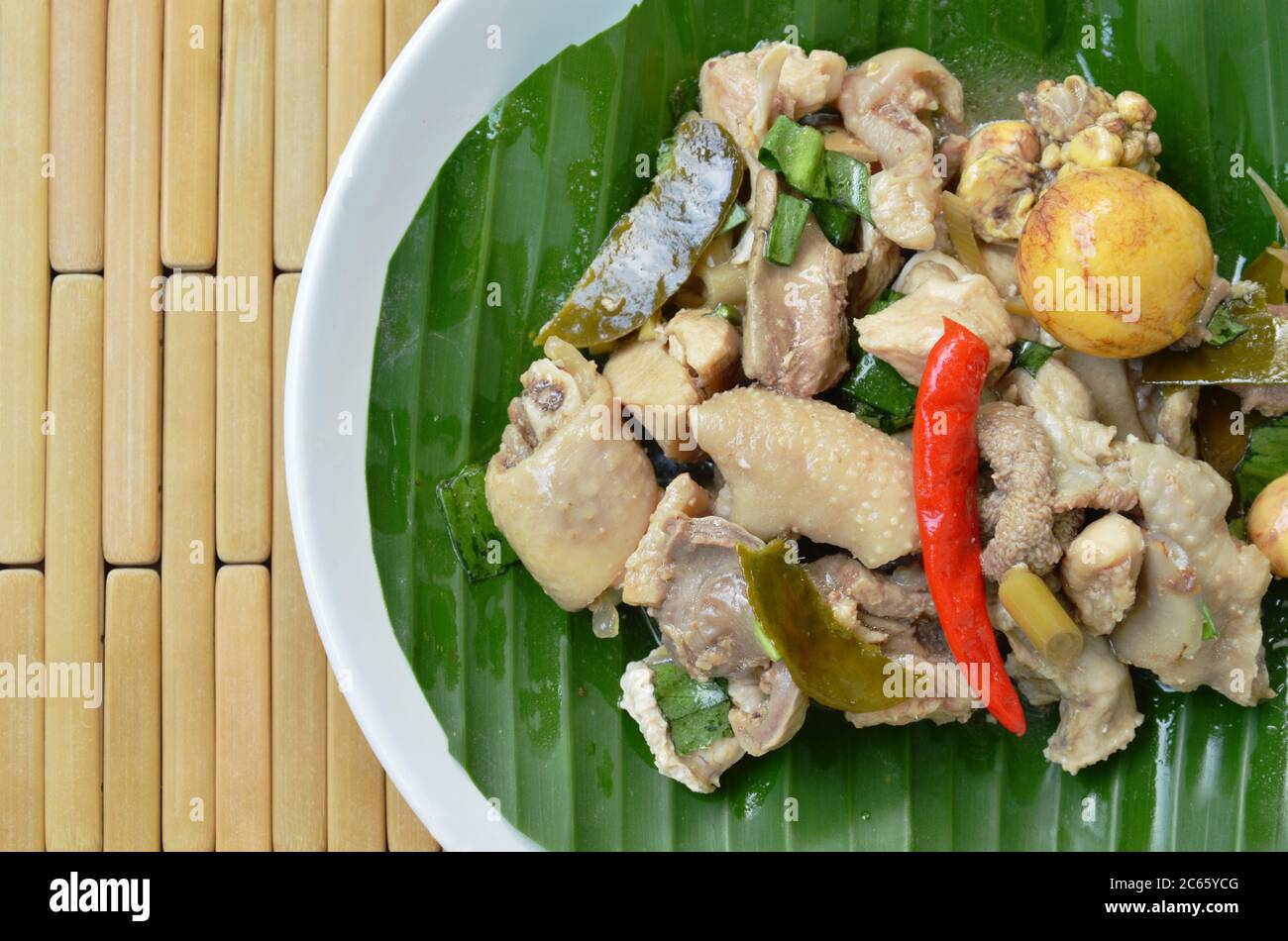 poulet cuit épicé et salade d'œufs sur feuille de banane dans l'assiette Banque D'Images