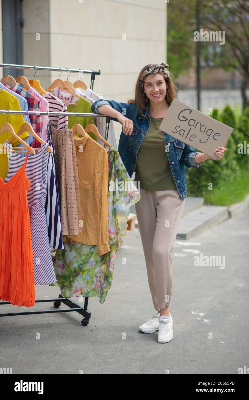 Joyeuse femme énergique organisant une vente de garage Banque D'Images