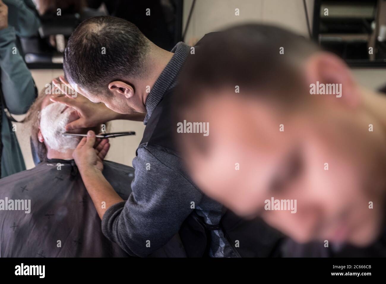 L'homme a un rasage par un barbier à Marrakech, au Maroc. Banque D'Images