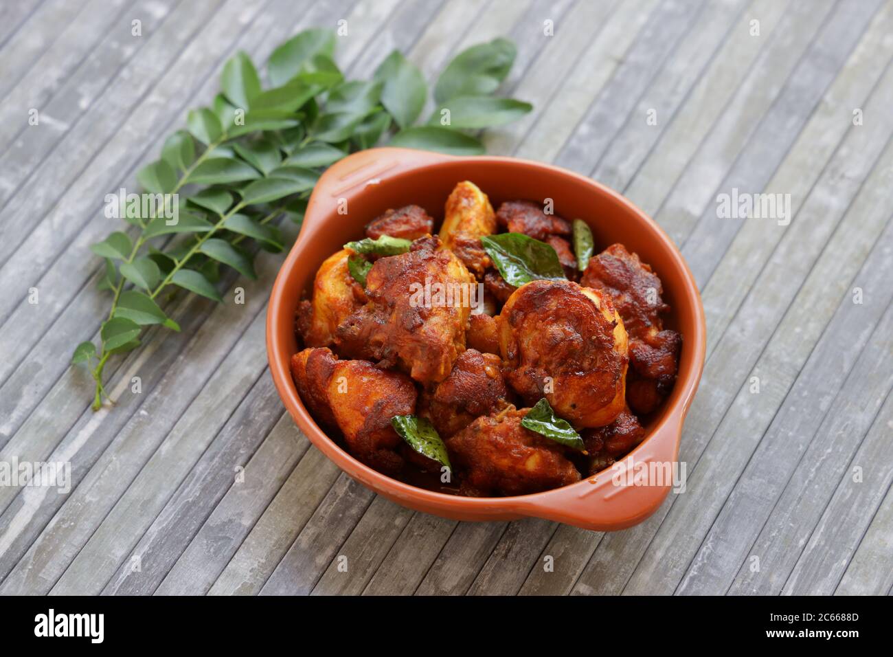 Poulet frit ou poulet frit kabab qui est bien garni de feuilles de curry dans une poêle noire avec fond gris ou des articles du terrorde Banque D'Images