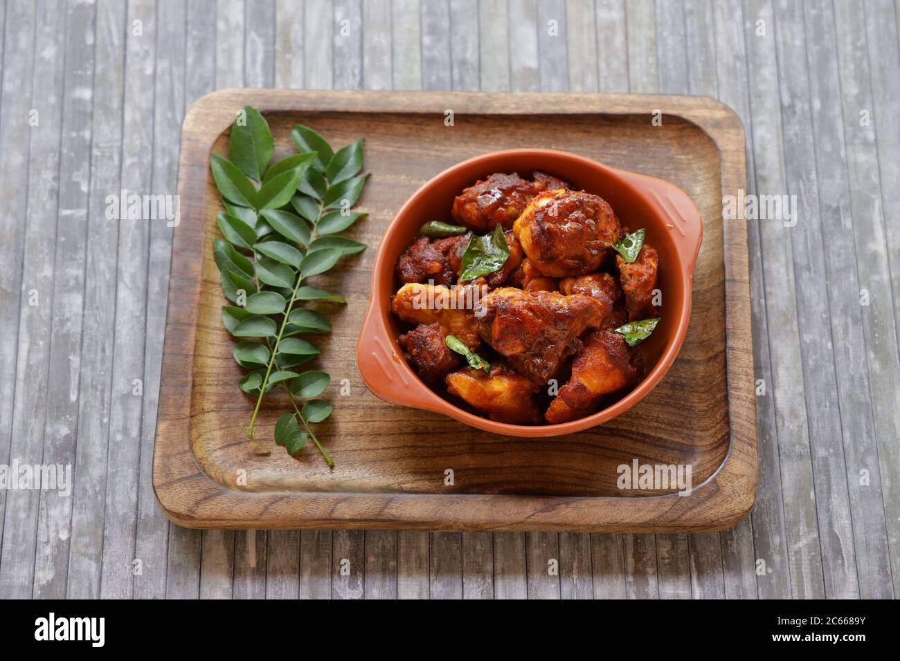 Poulet frit ou poulet frit kabab qui est bien garni de feuilles de curry dans une poêle noire avec fond gris ou des articles du terrorde Banque D'Images