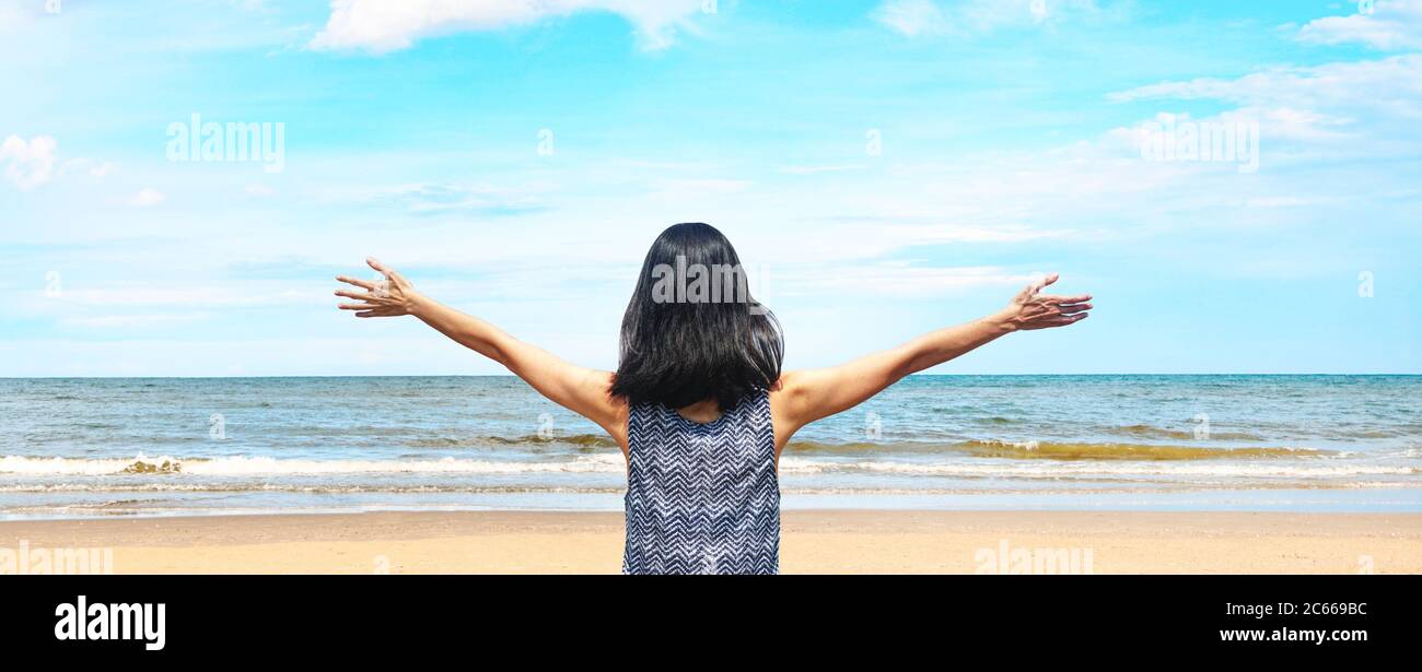 Vue de dos une femme heureuse avec arrière-plan panorama mer plage et ciel bleu Banque D'Images