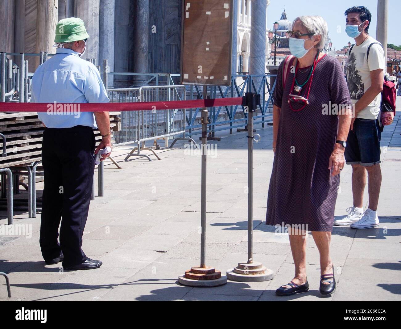 San Marco, Venise, Italie - juillet 2020. L'employé de l'entrée de la cathédrale scanne la fièvre de température corporelle touristique pour la prévention du covid-19. Peu de touristes sont de retour Banque D'Images