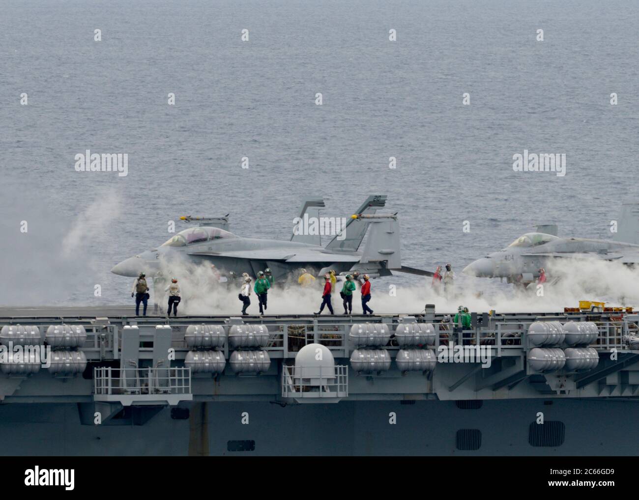 Un marin de la Marine américaine prépare un avion de chasse F/A-18 Super Hornet pour le lancement à partir du pont de vol du porte-avions de la classe Nimitz USS Nimitz lors des opérations à double porte le 6 juillet 2020 en mer de Chine méridionale. Banque D'Images