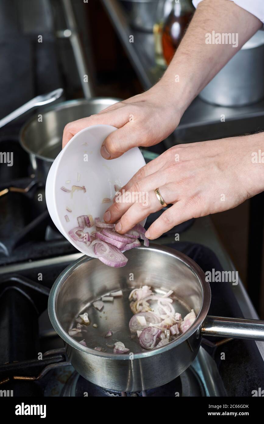 Préparation de la sauce béarnaise étape par étape, ajout d'échalotes hachées Banque D'Images