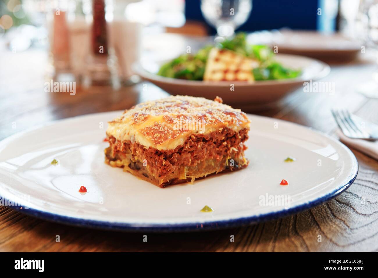 Moussaka et féta frite, cuisine grecque traditionnelle, sur table, tonifiée Banque D'Images