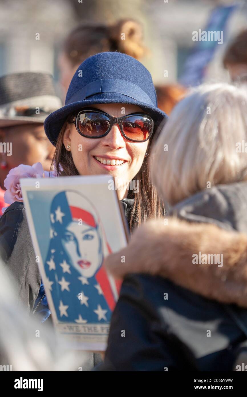 Femme souriante d'âge moyen, portant un chapeau et des lunettes de soleil, lors de la marche des femmes à Londres, le 2017 janvier Banque D'Images