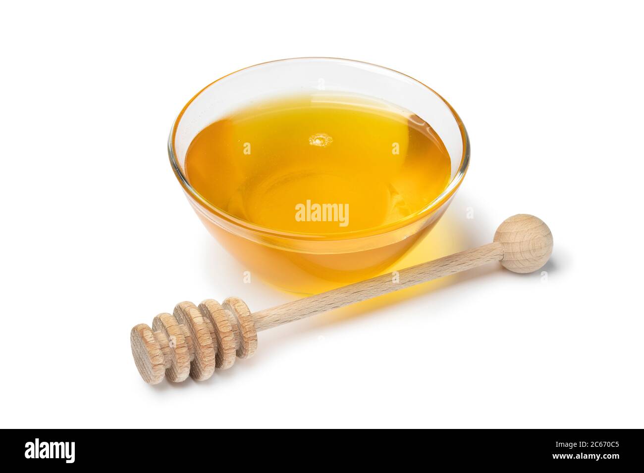 Bol en verre avec miel et un balancier en bois isolé sur fond blanc Banque D'Images