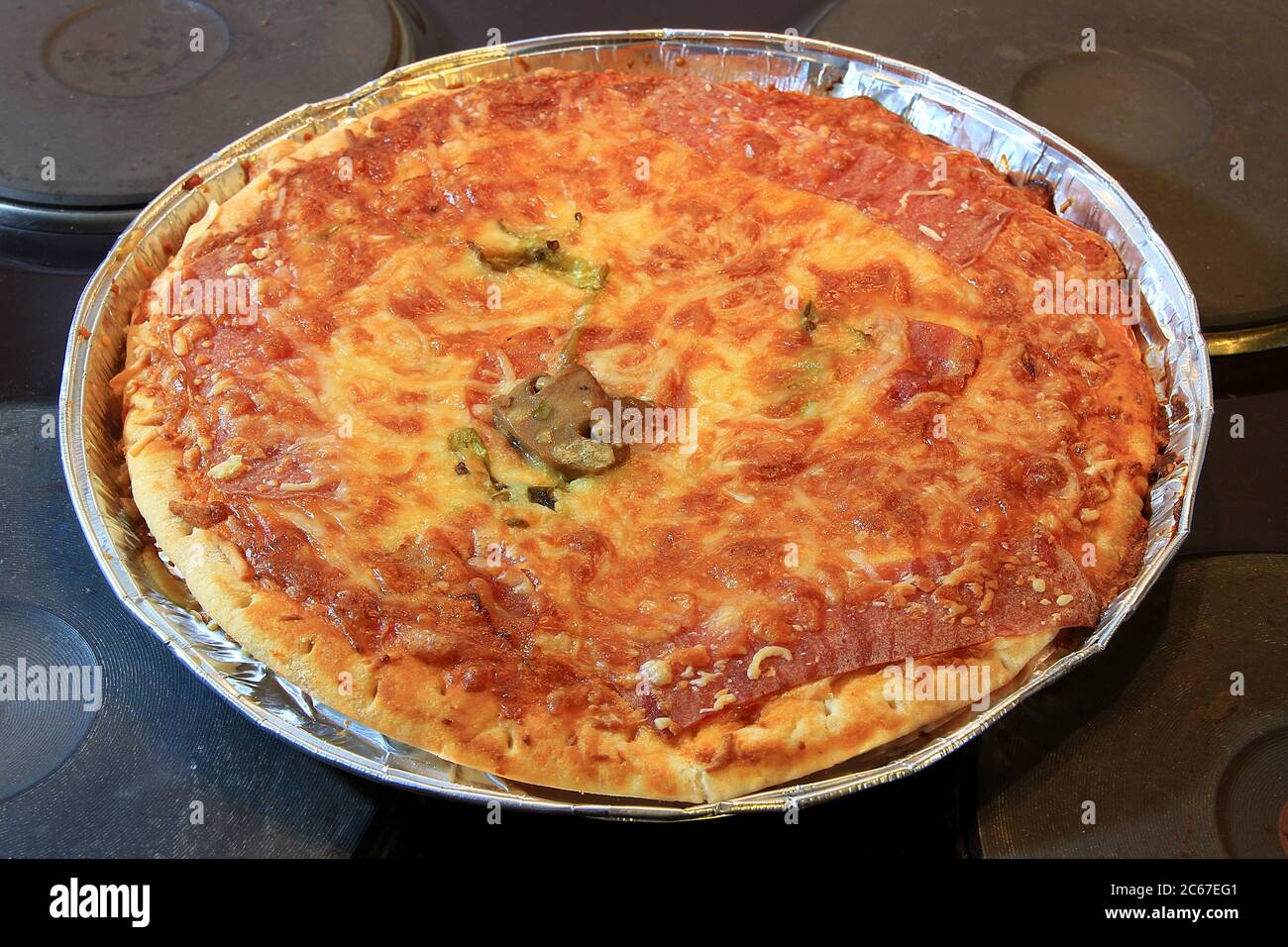 Pizza maison fraîchement cuite avec sauce tomate au fromage fondu et un champignon dans un plateau en aluminium juste à côté du four. Vue de dessus, Dep. Peu profonde Banque D'Images