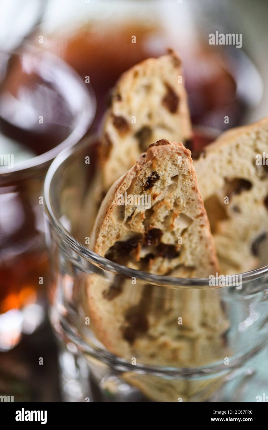 Gros plan de biscotti ou de cantucci italiens traditionnels faits maison avec raisins secs dans un verre servi avec du café en gros plan Banque D'Images
