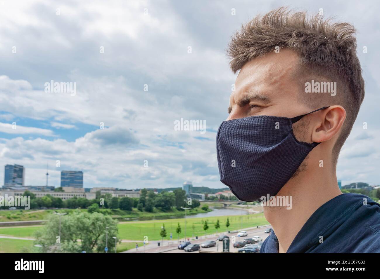 Portrait rapproché d'un homme dans un masque facial de protection à l'extérieur. Homme portant un masque de près en arrière-plan de la ville. Nouvelle normale. Concept de soins de santé pendant la cor Banque D'Images