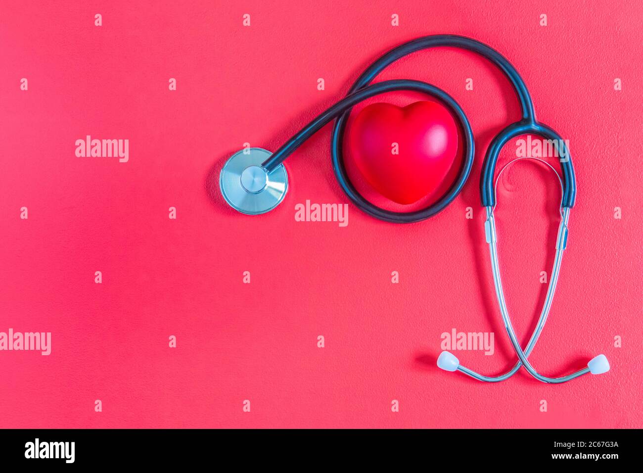 Stéthoscope médical avec cœur rouge sur fond rouge. Plan de stéthoscope et de coeur et isolé sur fond rouge. Maquette pour la Saint Valentin avec Banque D'Images
